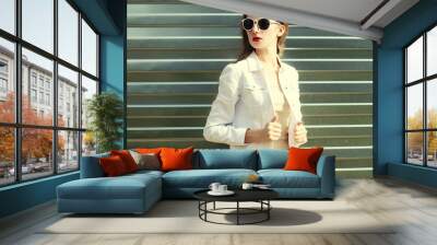 Fashion pretty woman in sunglasses and white denim jacket over m Wall mural