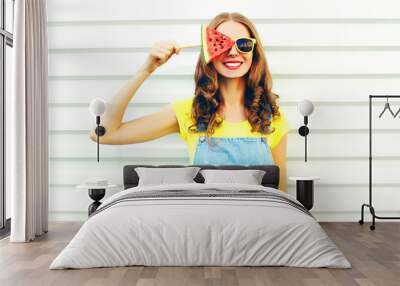 fashion smiling young woman holding a slice of watermelon in the form of ice cream over a white back Wall mural