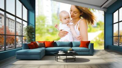 Happy mother and baby outdoors walking in summer day Wall mural