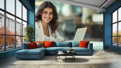 Happy successful businesswoman working on a laptop, smiling woman entrepreneur sitting in the office Wall mural