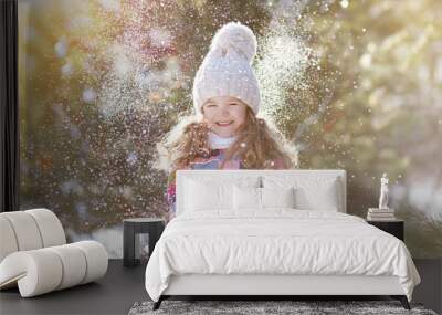 Joyful child having fun with snow in winter day Wall mural