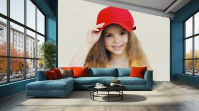 Portrait close up beautiful little girl kid with long hair wearing a red baseball cap Wall mural