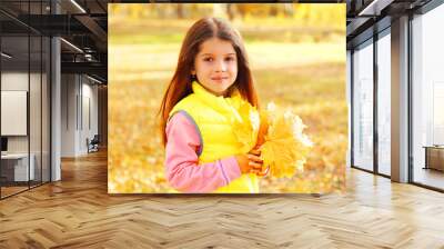 Portrait of beautiful little girl child with yellow maple leafs Wall mural