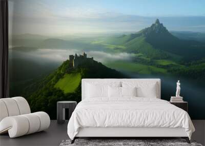 Castle ruins atop a hill with a stunning view of the valley and mountains as the morning mist clears Wall mural