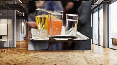 Waiter holding a tray with beverages during cocktail party Wall mural