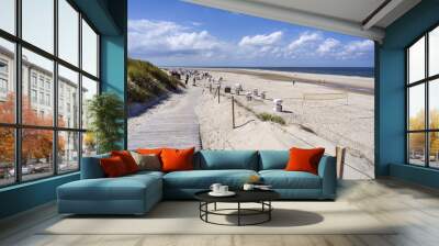 Germany, North Sea, Spiekeroog: Panorama view with people, beach chairs, green dunes on white beach of famous German touristic island - concept holiday luxury nature environment. August 17, 2018 Wall mural