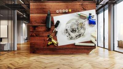 skull tattoo sketch with rotary machines, needles, grips on wooden background Wall mural