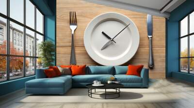 A white dinner plate with clock hands, a fork, and a knife sit on a wooden table Wall mural