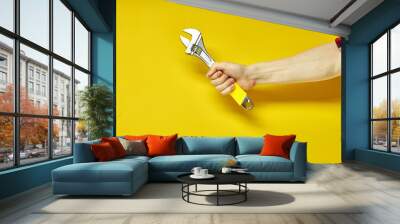 Adjustable wrench with yellow rubberized handle, isolated on yellow background Wall mural