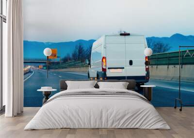 White Minivan at road. Mini van auto vehicle on driveway. European van transport logistics transportation. Auto with driver on highway. Wall mural