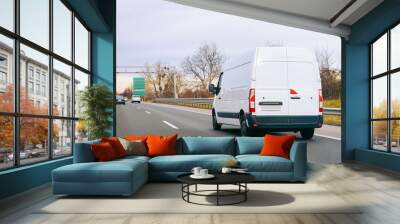 White Minivan on road. Mini van auto vehicle on driveway. European van transport logistics transportation. Auto with driver on highway. Wall mural