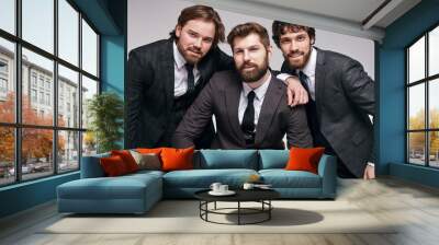 Bearded guys in classic trendy suit posing at camera, handsome young men in tuxedo looking at camera, having imperious and confident look, isolated in studio Wall mural