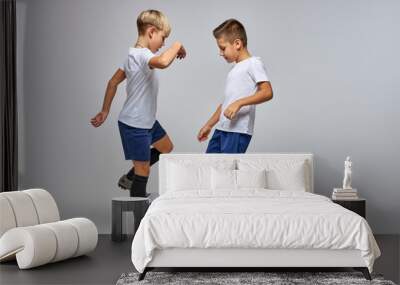 boys playing soccer game, studio portrait of caucasian soccer players children in uniform kicking soccer ball. game of football tournament for kids Wall mural