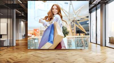 cheerful girl gets pleasure from shopping at modern shopping center,lifestyle, hobby, interests. happiness, best day for shopping, successful goods, success Wall mural