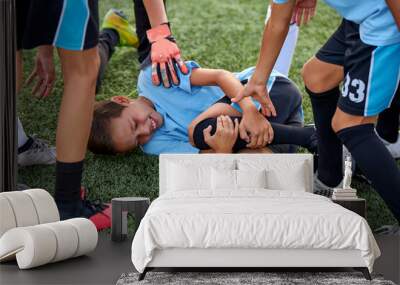 friendly team support their friend having ache in legs, they ask about his feelings, want to help, boy is lying on grass Wall mural