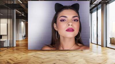 Funny girl represents as small cat. Woman with bright makeup hairstyle of girl with leather cat ears having fun. On white background not isolated. Girl with cat ears Wall mural