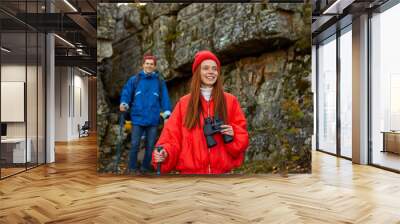 group of young caucasian people are happy on mountains, enjoy travelling together, they use binocular for better contemplation of the beauty of the mountains and nature around Wall mural