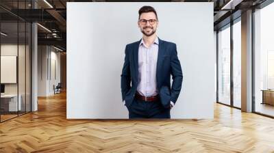 Handsome man in a suit keeps his hands in his pockets Wall mural