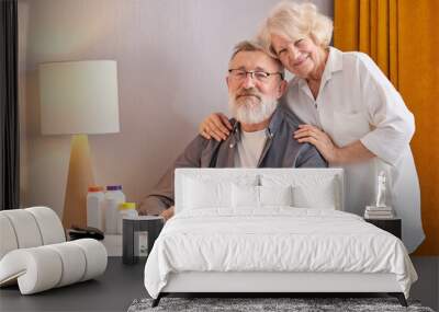 happy old age without disease. senior couple at home, behind table with pills Wall mural