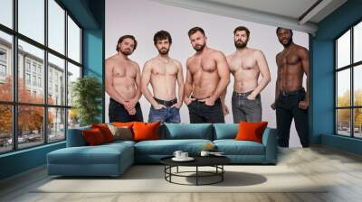 Interracial group of young shirtless men posing seriously at camera, sexy guys in jeans having muscular body, fit and strong. people, models, fashion, masculinity concept Wall mural