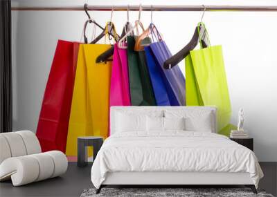 multicolored paper bags hang on hangers on white background-isolate Wall mural