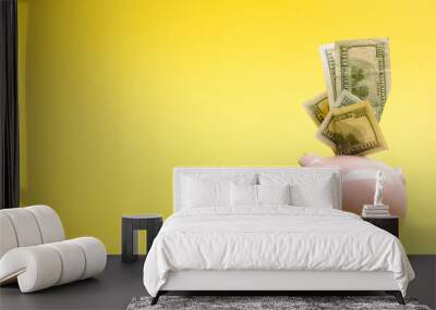 Piggy bank isolated on yellow background. Savings concept Wall mural