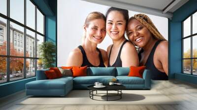 natural beauty concept. three diverse females in black sportswear smiling at camera, african caucasian asian women with natural beauty Wall mural