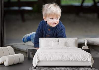 Little baby boy outdoors playing in sandbox. Wall mural