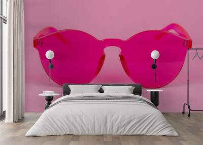 Plastic pink glamorous glasses on a pink background. Wall mural