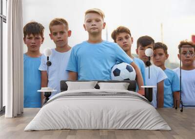 portrait of confident team of young football players posing at camera, athletic boys in uniform going to play football or soccer. in stadium Wall mural