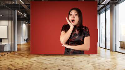 Korean emotional girl on a red background in the studio Wall mural