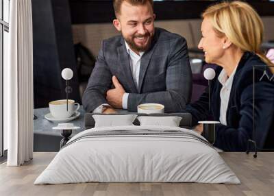 two business partners chatting over a cup of coffee, thinking and talking, discussing business ideas and projects, in restaurant Wall mural