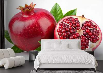 Two pomegranates, one whole and one sliced in half, reveal juicy red seeds. Green leaves surround the fruits, highlighting their freshness and rich color Wall mural