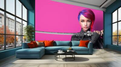 Portrait of a young beautiful cyberpunk girl looking at the camera and holding a futuristic katana sword with two hands. Urban woman with short red hair and blue eyes. 3d render on a pink background. Wall mural