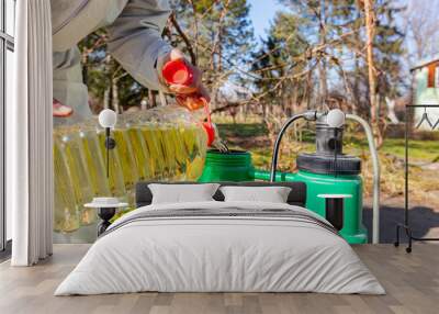 Gardener is blending substance with water in proper scale for sprinkles fruit trees Wall mural