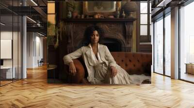 a photo of a gorgeous young african woman sitting on a couch in a luxurious posh living room, parisian style interior with tall windows, white paneled walls, fireplace, golden sophisticated decoration Wall mural