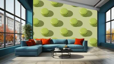 Hard light pattern of a green macaron pastry photographed on light green surface Wall mural