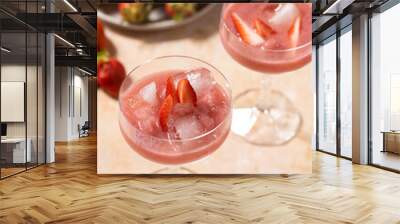 Two glasses with red strawberry dessert with ice cubes and crashed ice and strawberry slices, close up Wall mural