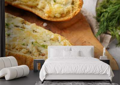 Two halves of garlic and butter bread - baguette on a wooden board, sea salt, pepper, dill and garlic cloves on a grey concrete background, top view Wall mural