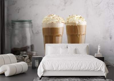 Two tall glasses with cold coffee drink frappe - iced cappuccino with whipped cream on a marble board Wall mural