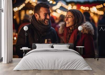 young cheerful people drinking mulled wine at the christmas market on a winter vacation in warm winter clothes, airy lights and bokeh in the background Wall mural