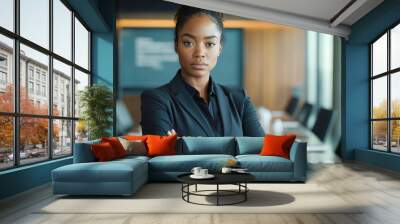 Confident businesswoman standing in modern boardroom with arms crossed Wall mural