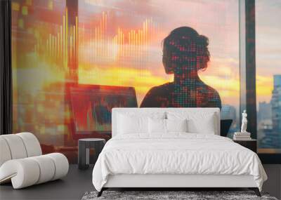 Silhouette of person analyzing financial data on laptop during sunset Wall mural