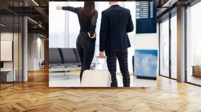 Business people in formal clothing walking with wheeled bags at airport terminal Wall mural