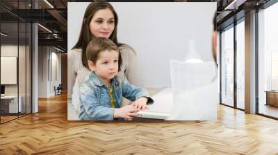 Scared boy with his mother sitting at the pediatrician doctor, psychologist Wall mural