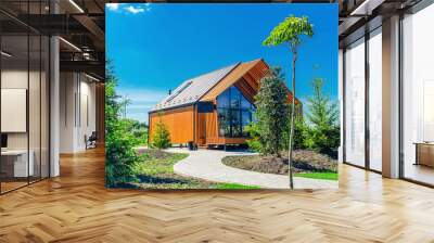 Small barnhouse house on a plot with a path, trees and bushes under a blue sky Wall mural