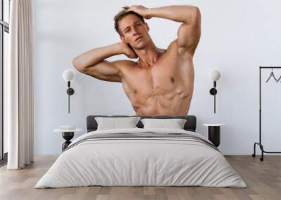 Portrait of sexy man with sporty body posing on white background Wall mural