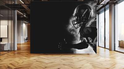 American football player. Sportsman with ball in helmet on stadium in action. Wall mural