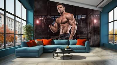 Young handsome sportsman bodybuilder weightlifter with an ideal body, after coaching poses in front of the camera, abdominal muscles, biceps triceps. In sportswear. Wall mural