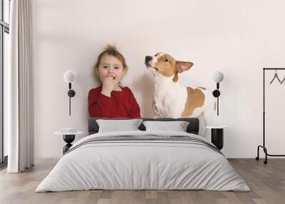 Child girl and jack russell dog have fun at home Wall mural